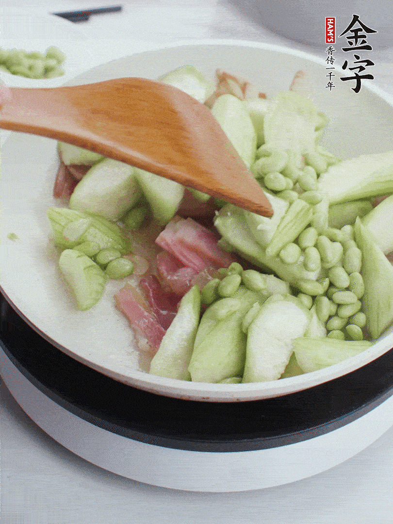 依次下絲瓜、青豆翻炒，炒至絲瓜打蔫縮小。