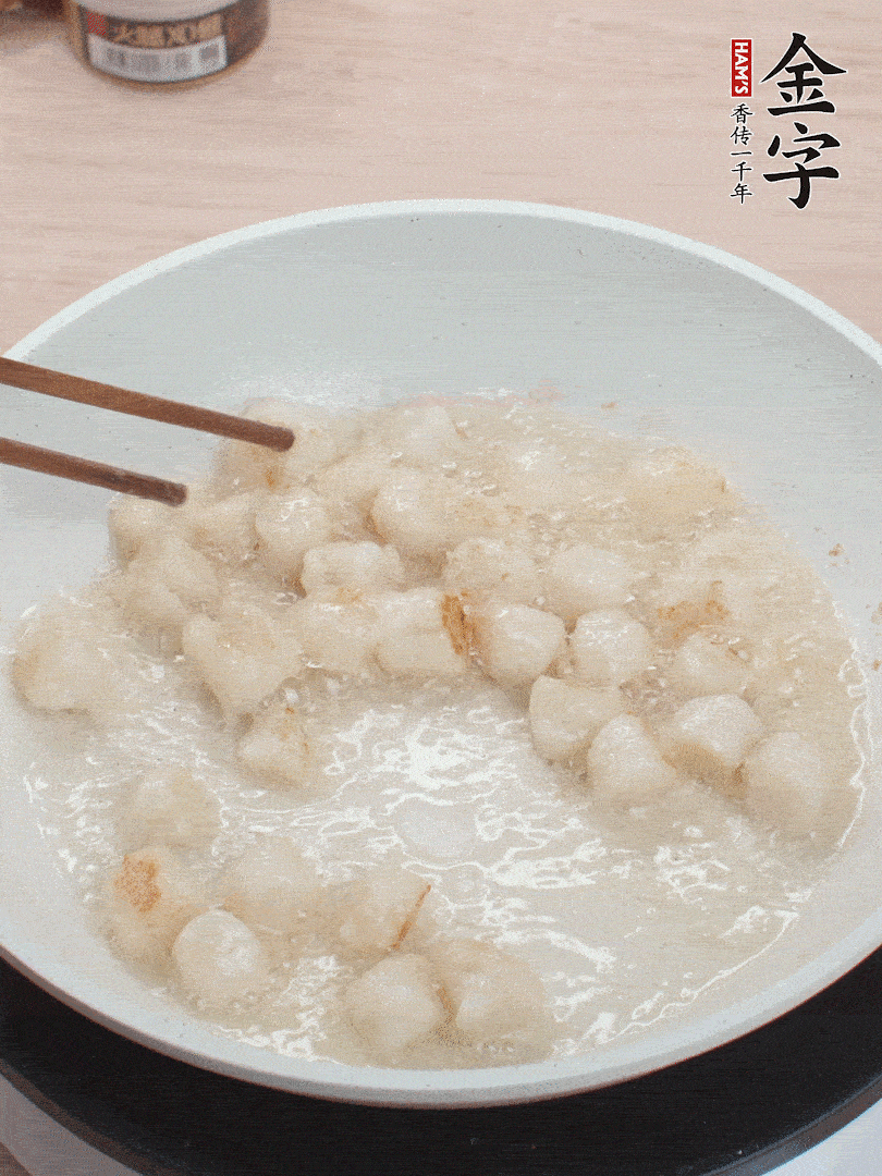 油溫4成熱，鮮貝蘸干淀粉下鍋煎，一面微黃后翻面。
