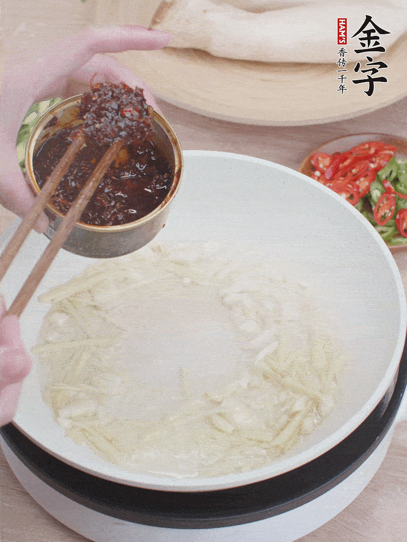 起鍋熱油，姜蒜、金字火腿干貝醬煸香。