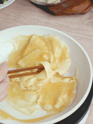 油6成熱時，下雞蛋液，邊緣凝固時翻拌成塊狀。
